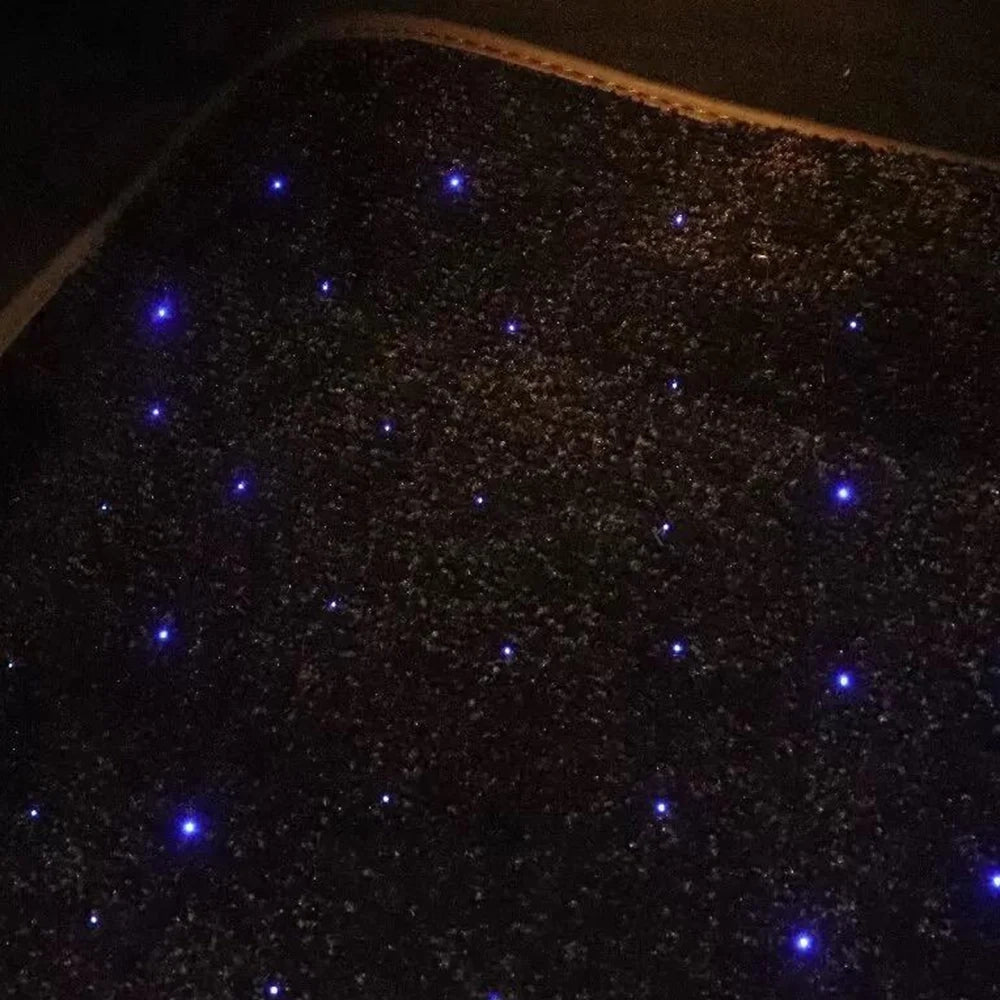 Close-up of black car floor mat with blue fiber-optic star light dot pattern
