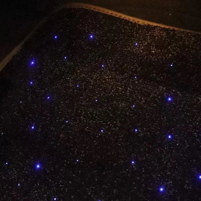 Close-up of black car floor mat with blue fiber-optic star light dot pattern
