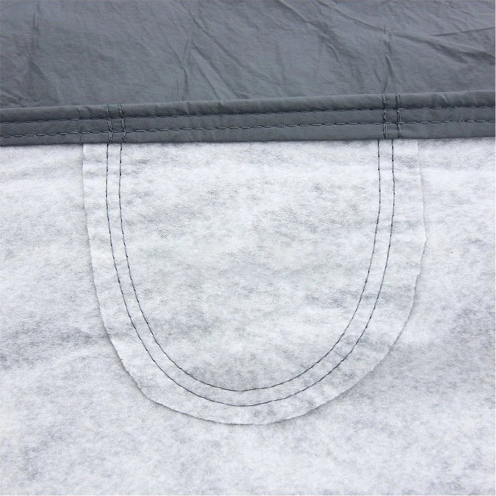 Gray non-woven car cover edge with curved stitched seam and reinforced stitching